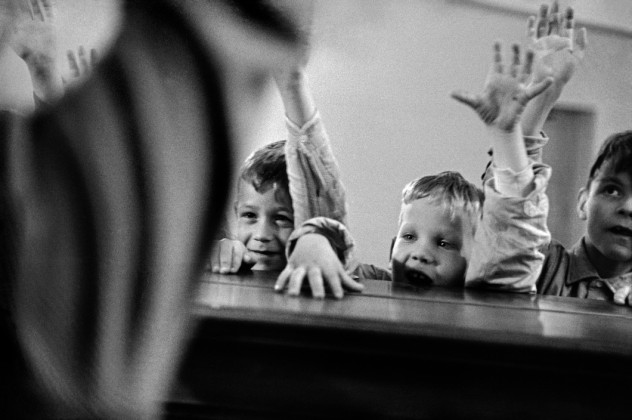 SWITZERLAND. Zurich. 1955. Special school for deaf-mute children that teaches them to hear through their vibratory senses. Music education. Children raise their hands according to the teacher's instructions when they have heard with their fingertips the lively rythm played on the piano.